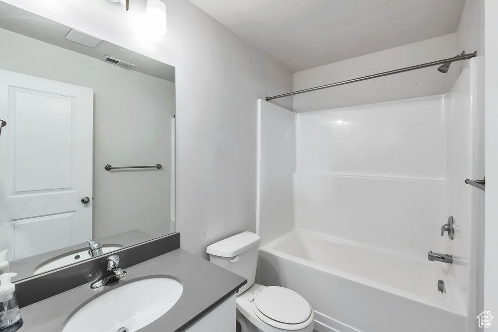 Full bath with toilet, vanity, and shower / tub combination