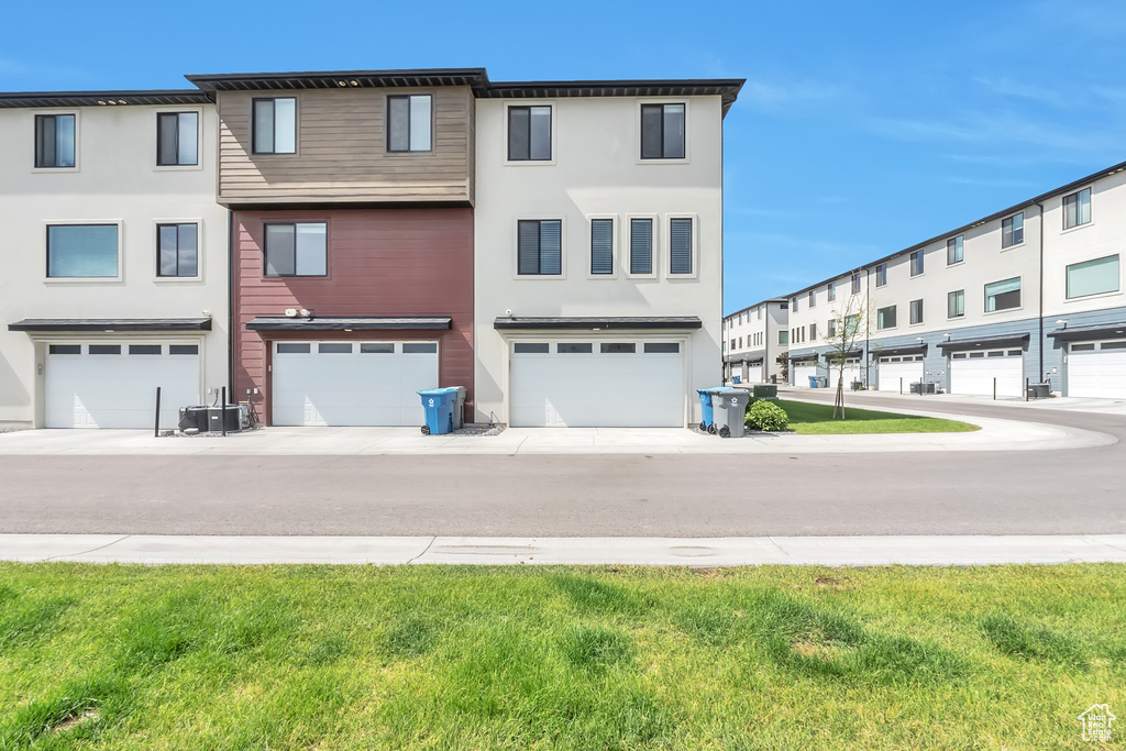 View of front of home featuring an attached garage and stucco siding