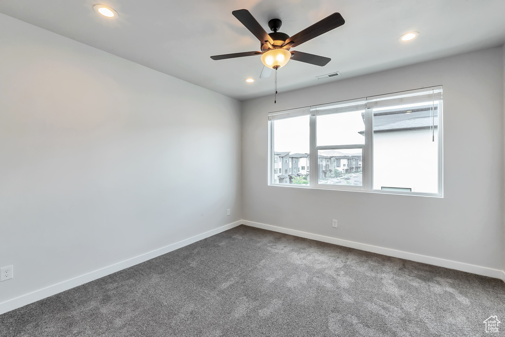Unfurnished room featuring dark carpet, recessed lighting, baseboards, and ceiling fan