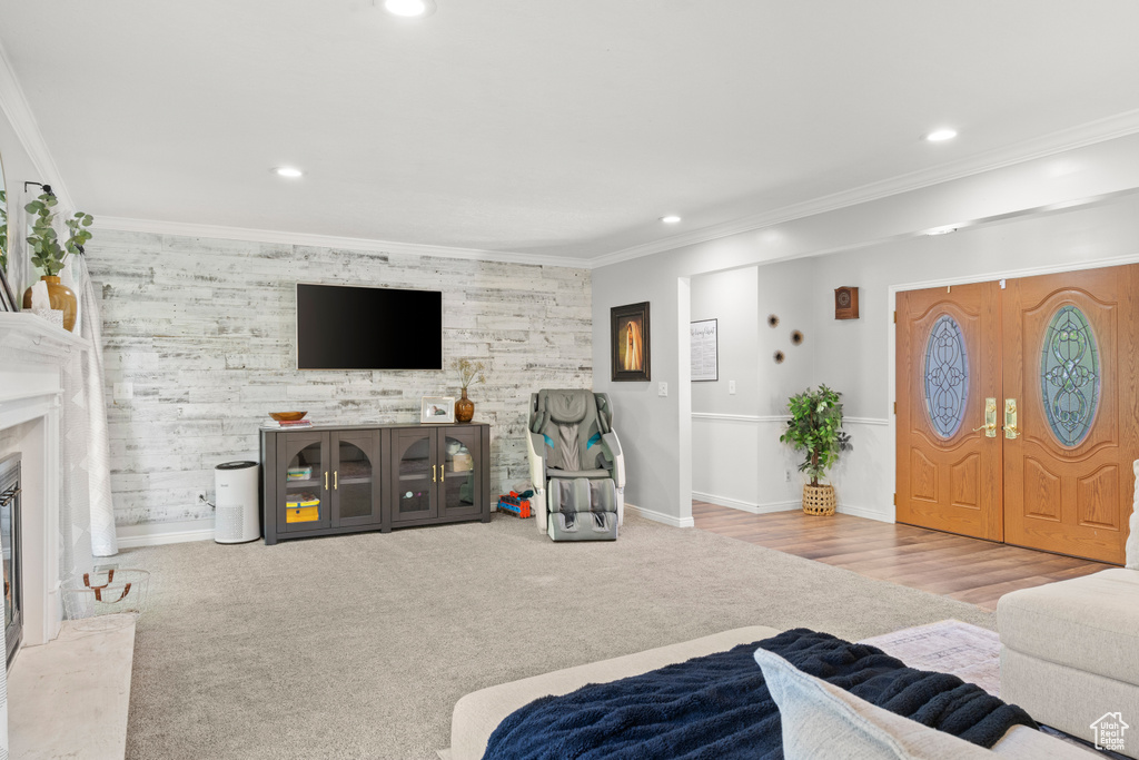 Carpeted living room featuring recessed lighting, ornamental molding, a premium fireplace, and an accent wall