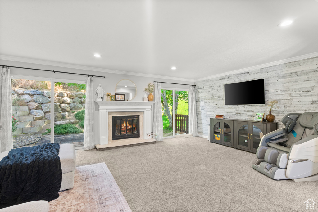 Living room with carpet floors, crown molding, a glass covered fireplace, and recessed lighting
