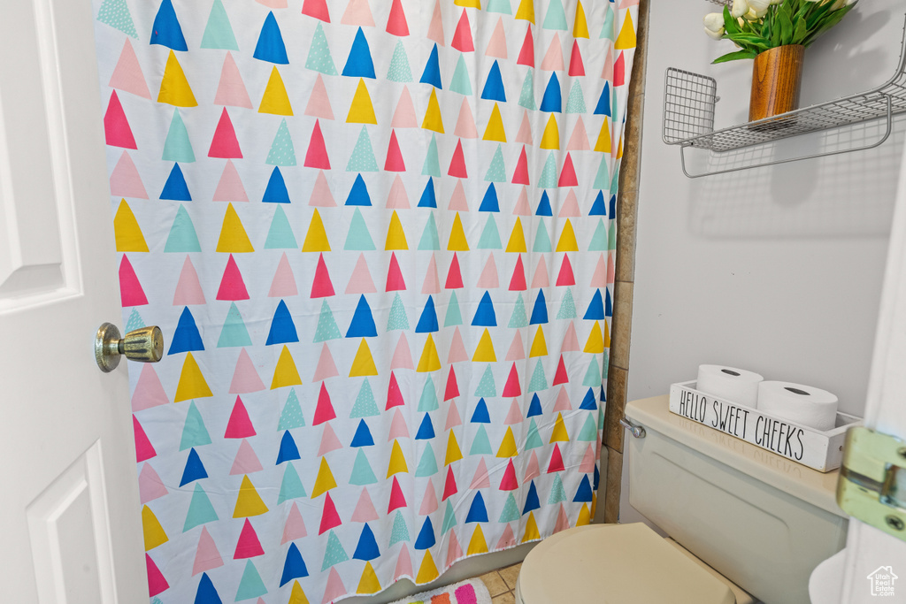 Full bath featuring toilet and a shower with shower curtain