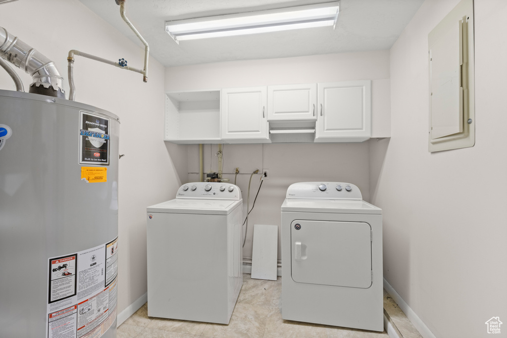 Laundry room with gas water heater, cabinet space, washing machine and dryer, and electric panel
