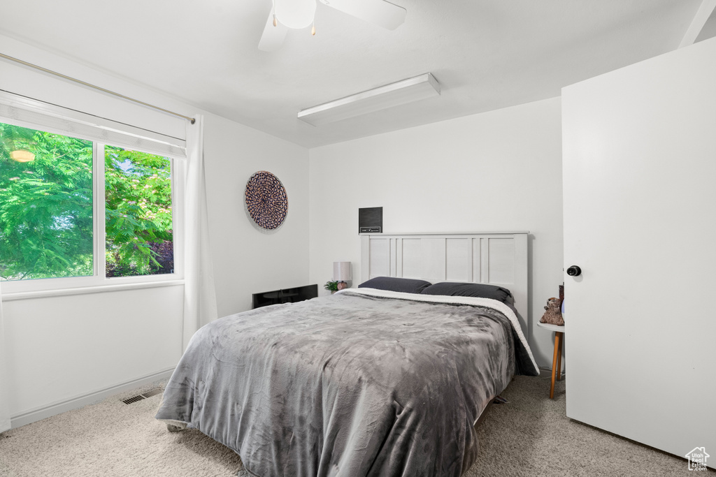 Carpeted bedroom featuring ceiling fan