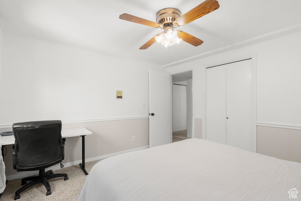 Carpeted bedroom with a closet and ceiling fan