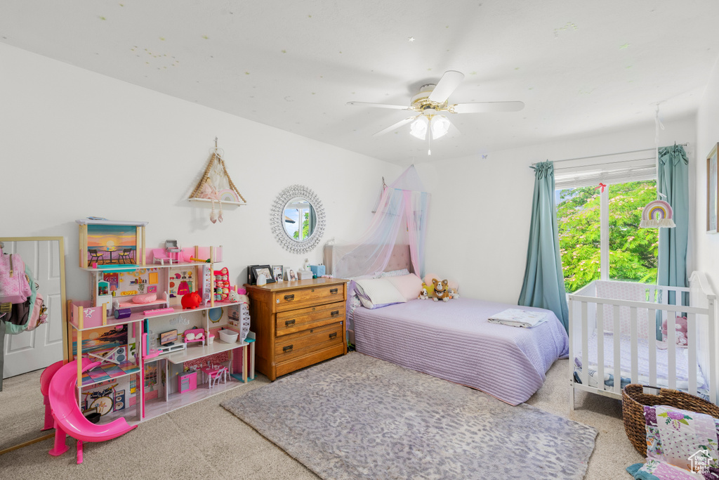 Carpeted bedroom featuring a ceiling fan