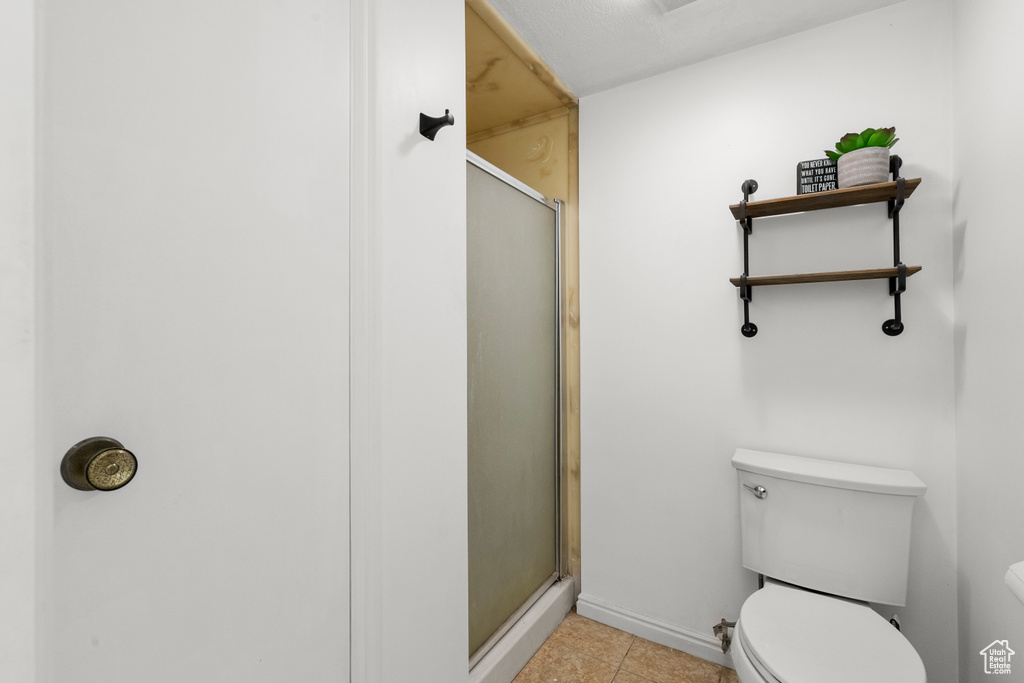 Bathroom with a shower stall and tile patterned floors