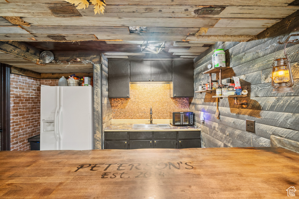 Kitchen featuring white fridge with ice dispenser and open shelves