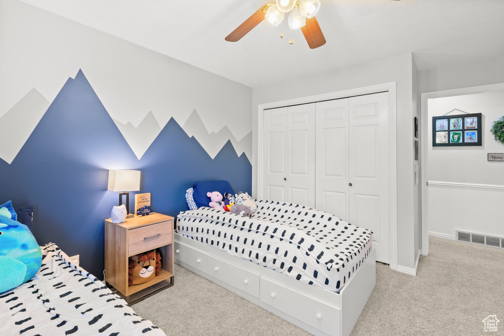 Carpeted bedroom featuring a closet and a ceiling fan