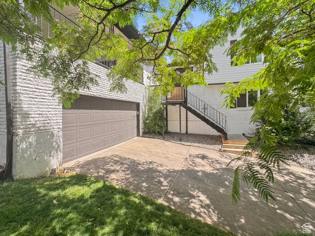 View of yard featuring a garage and concrete driveway