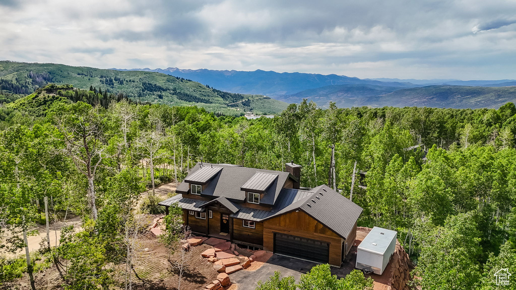 View of subject property featuring a heavily wooded area and a mountainous background