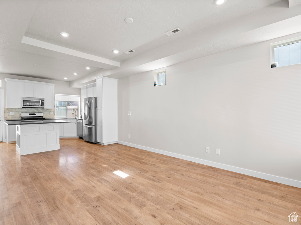 Kitchen with stainless steel appliances, recessed lighting, open floor plan, backsplash, and dark countertops