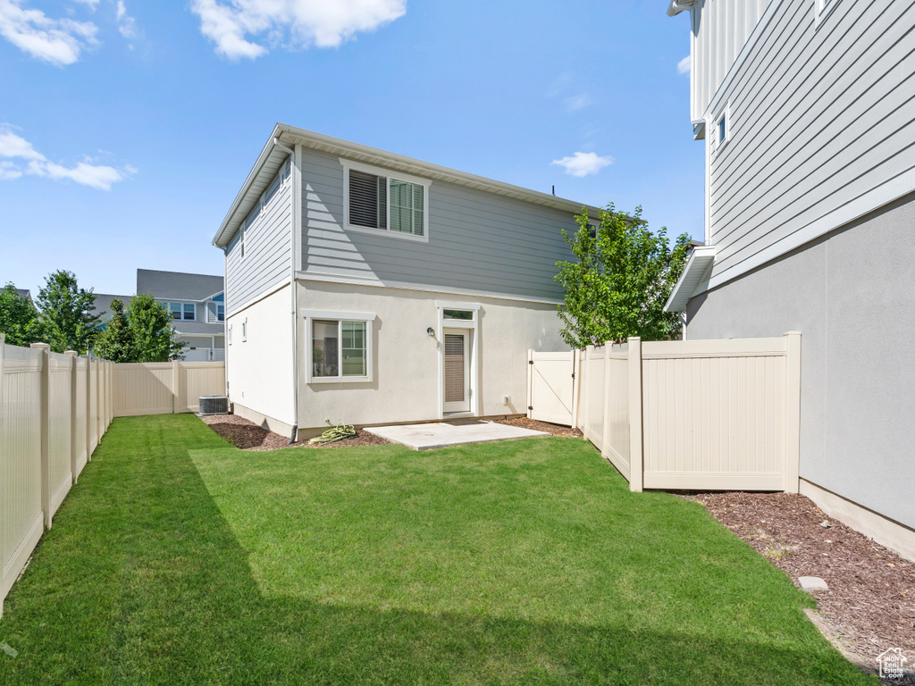 Back of house featuring a fenced backyard, a gate, a patio area, and stucco siding