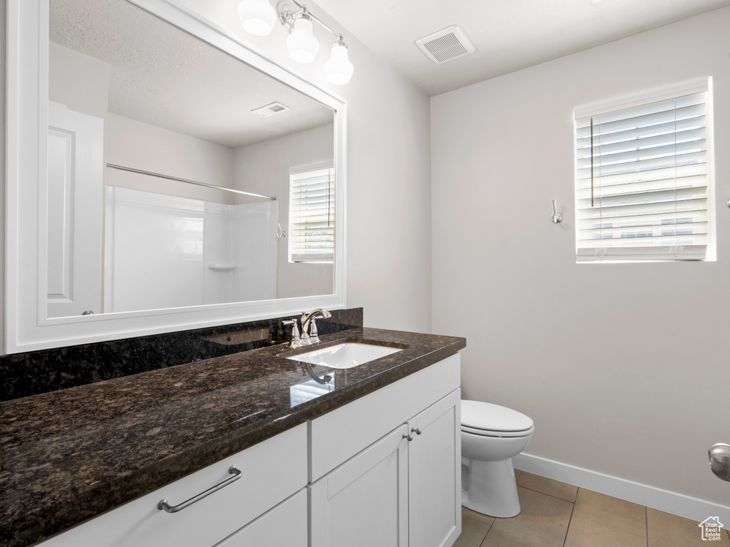 Bathroom featuring vanity, tile patterned floors, and a shower