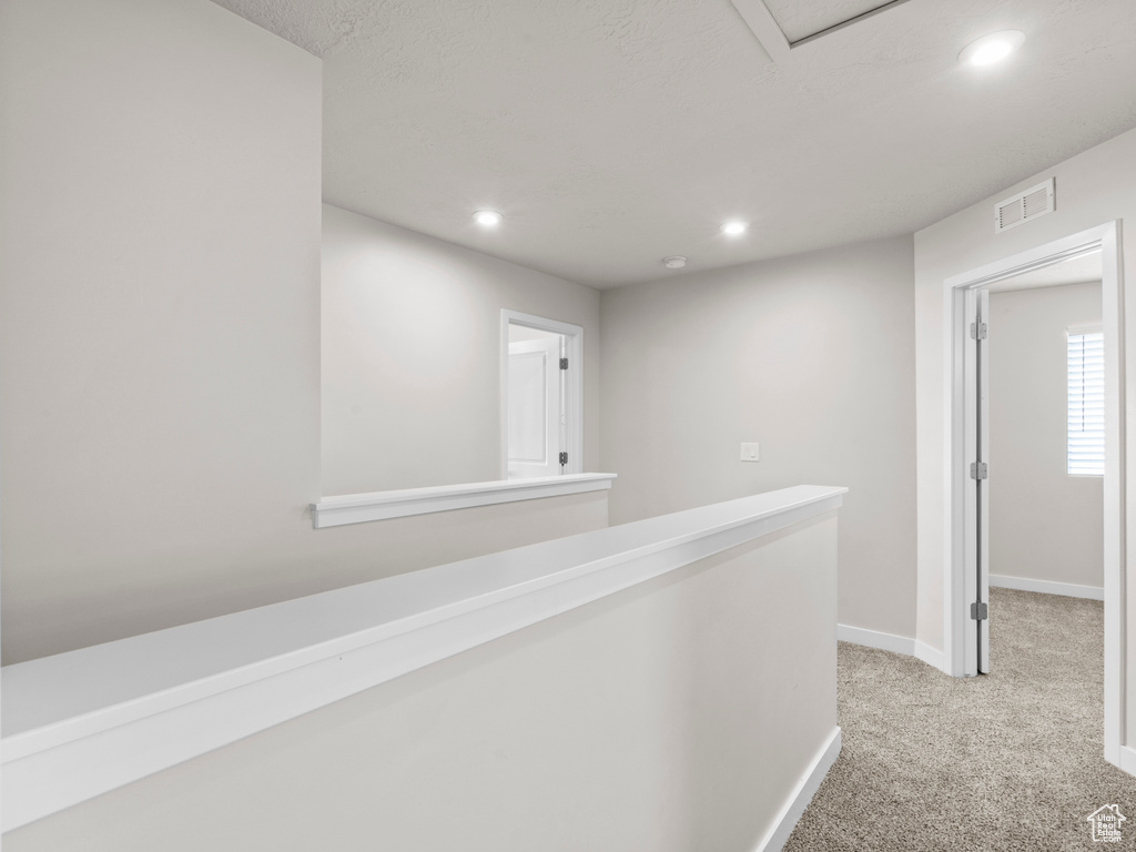 Corridor featuring light colored carpet and recessed lighting