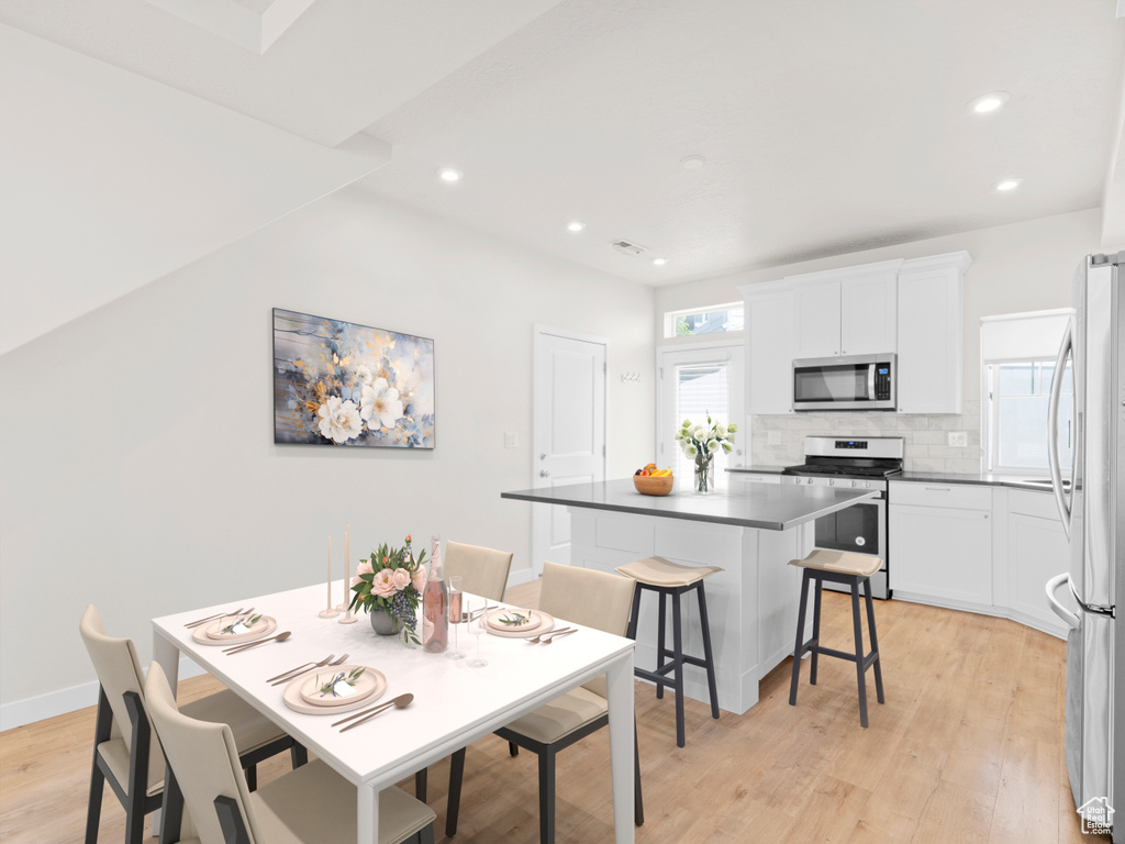 Dining area featuring light wood finished floors and recessed lighting