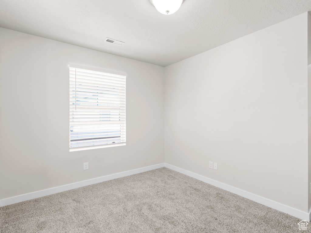 Spare room featuring carpet floors and baseboards