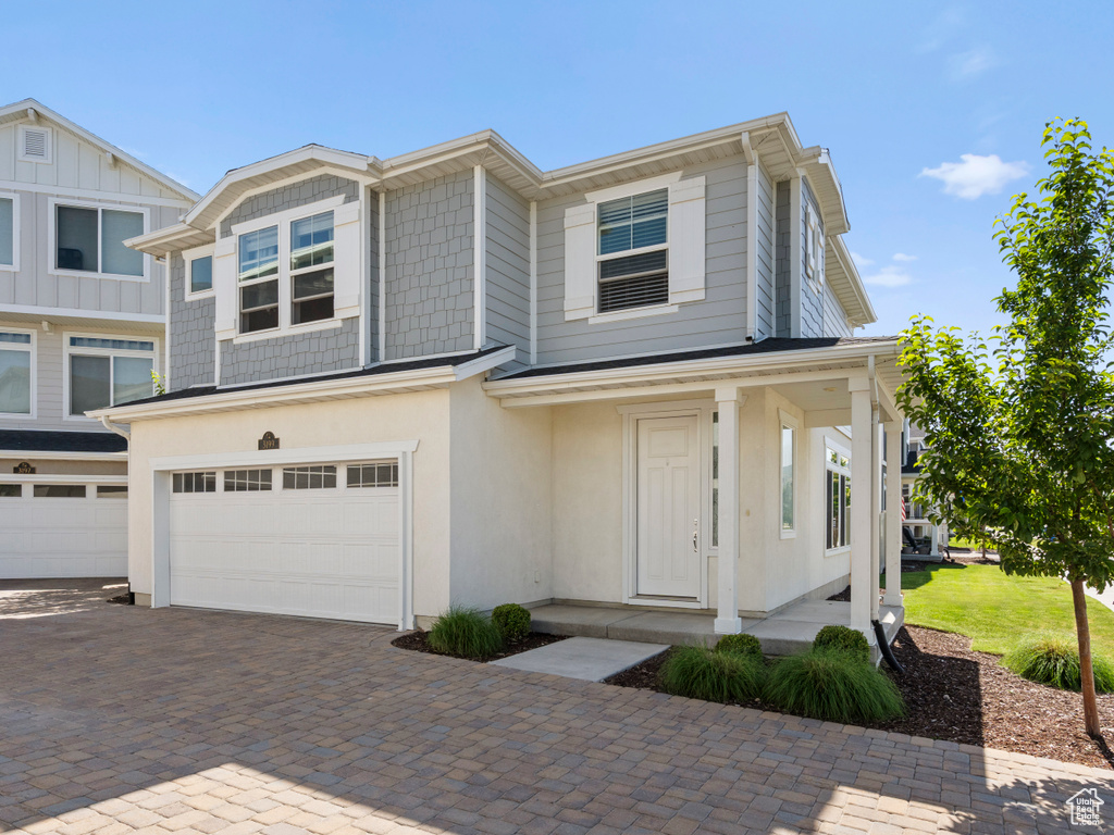 Townhome / multi-family property with a garage and decorative driveway