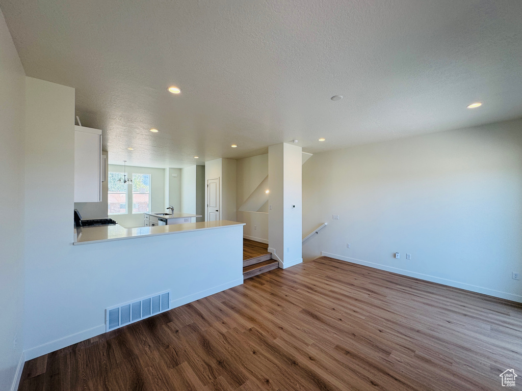 Unfurnished living room featuring wood finished floors, recessed lighting, and a textured ceiling