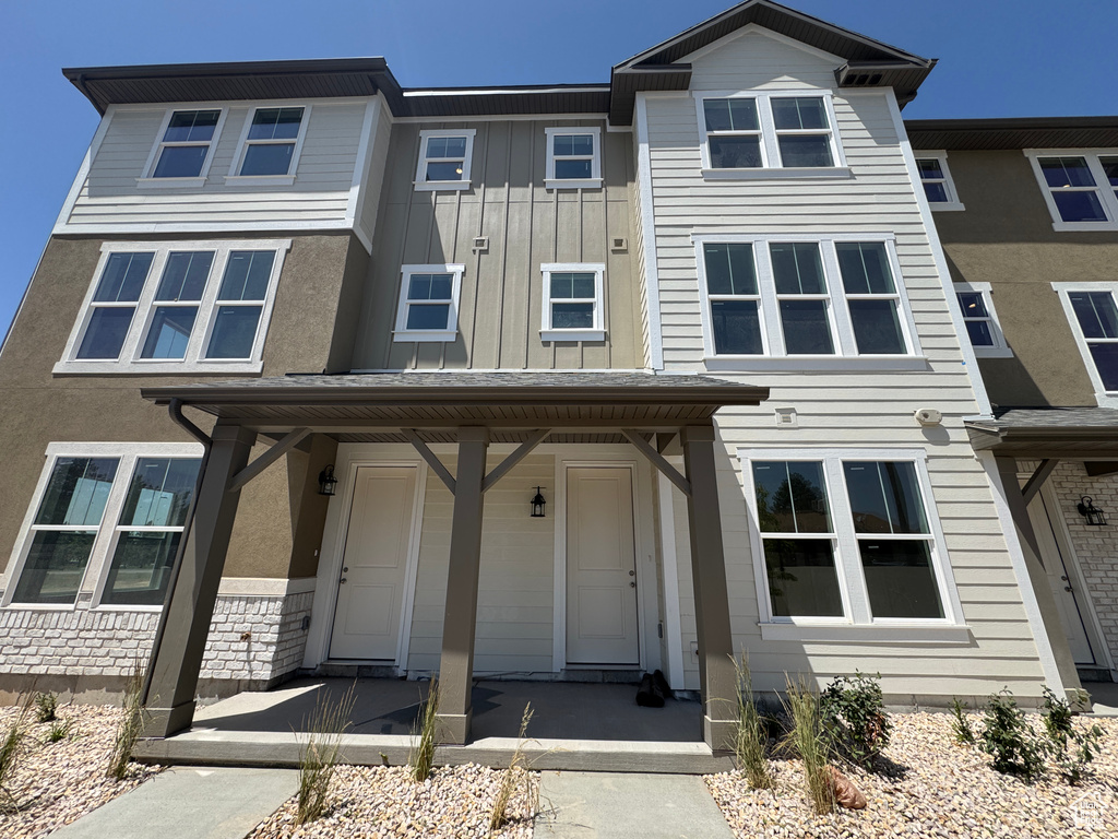 View of property featuring a porch, board and batten siding, and stucco siding
