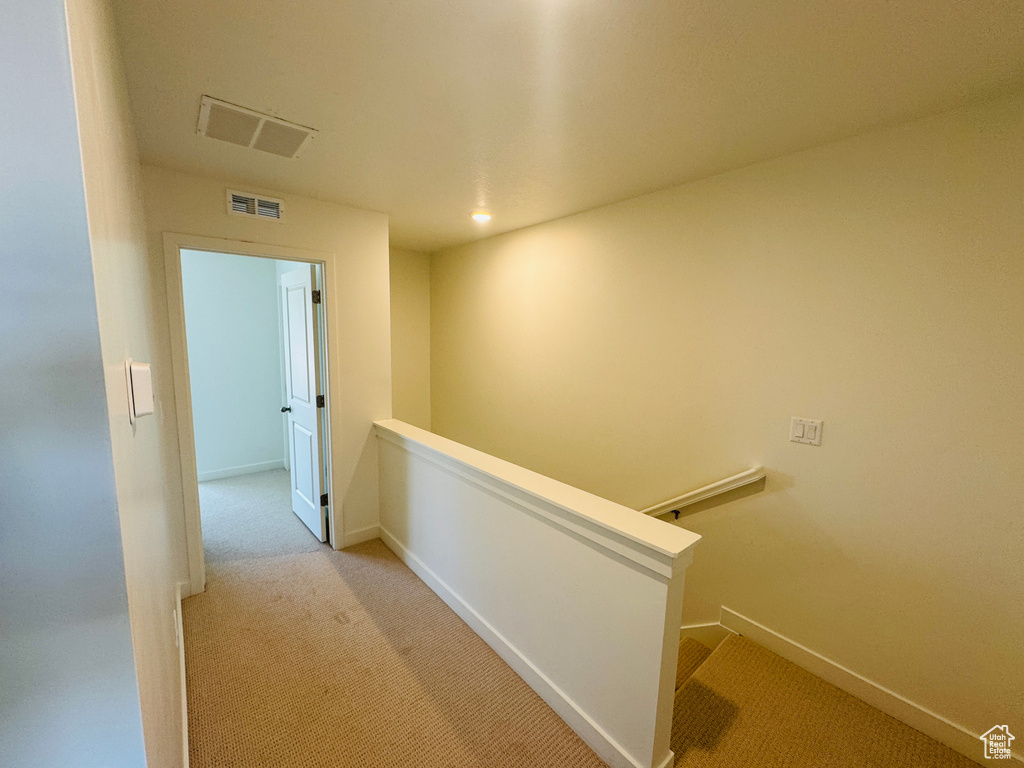 Hallway featuring an upstairs landing and carpet floors
