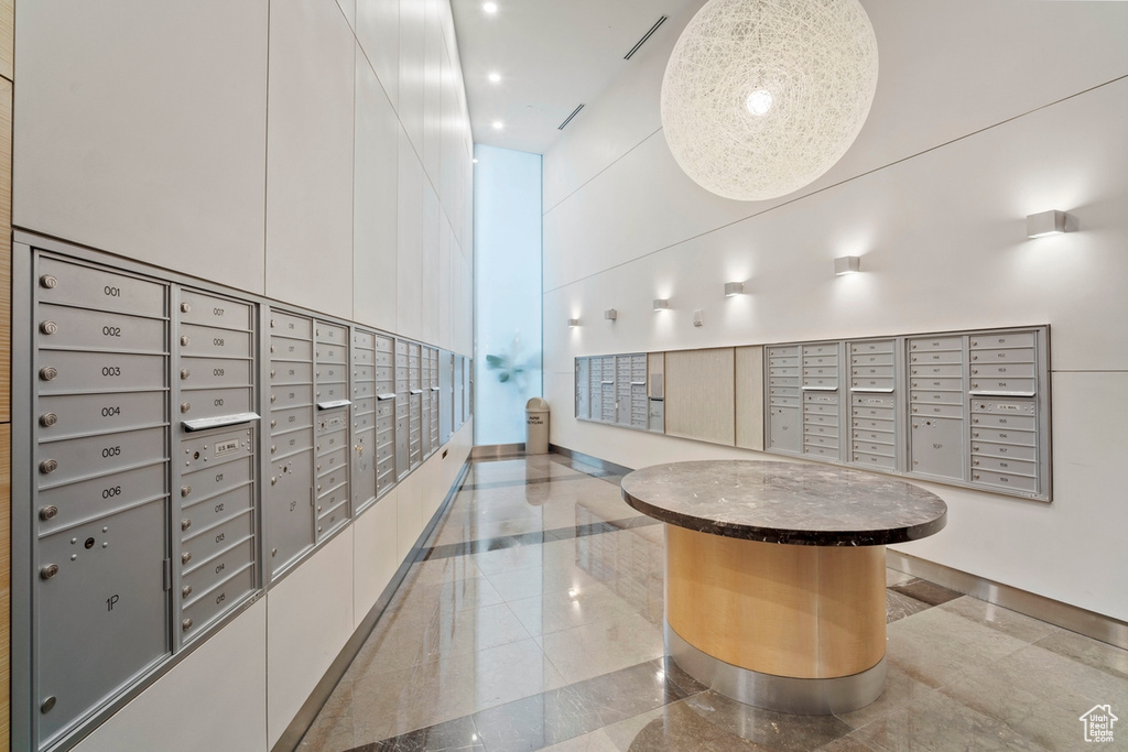 Surrounding community featuring mail area, a towering ceiling, and recessed lighting