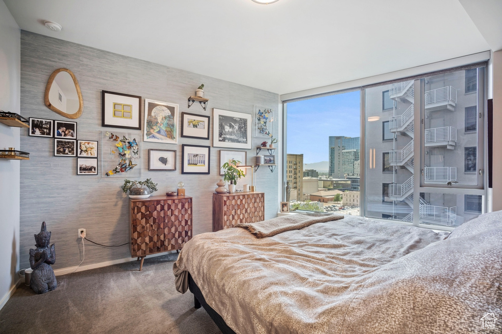 Bedroom featuring carpet floors, expansive windows, and a city view