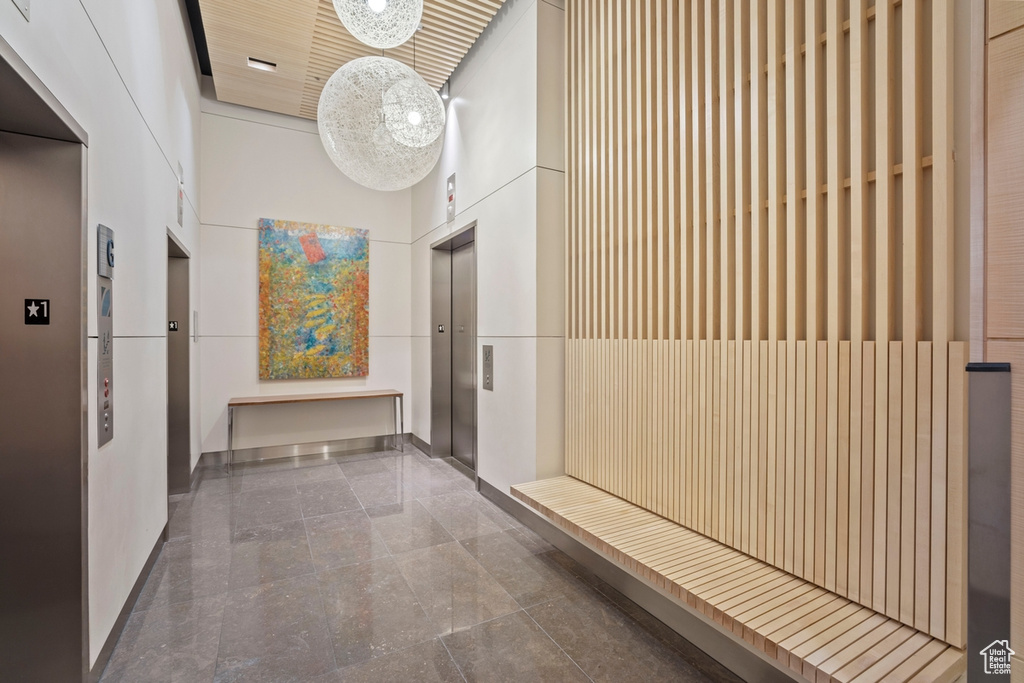 Hallway with a high ceiling and elevator