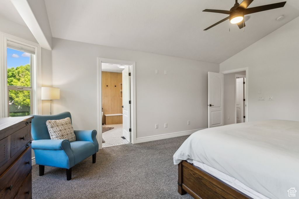 Carpeted bedroom with vaulted ceiling, ensuite bathroom, and a ceiling fan