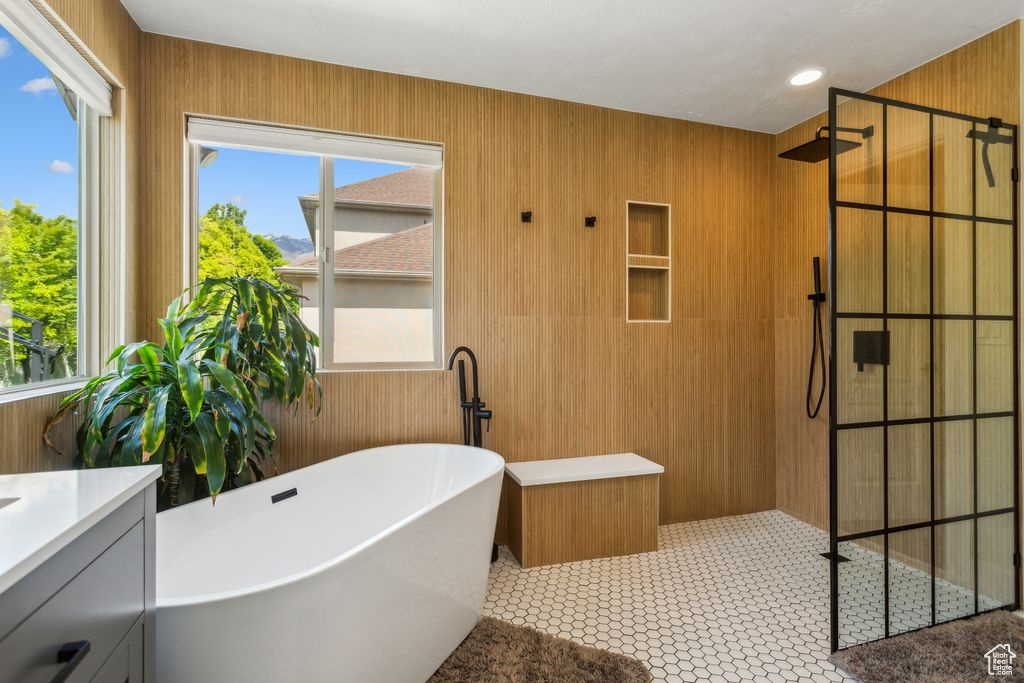 Full bath featuring walk in shower, a soaking tub, plenty of natural light, and vanity