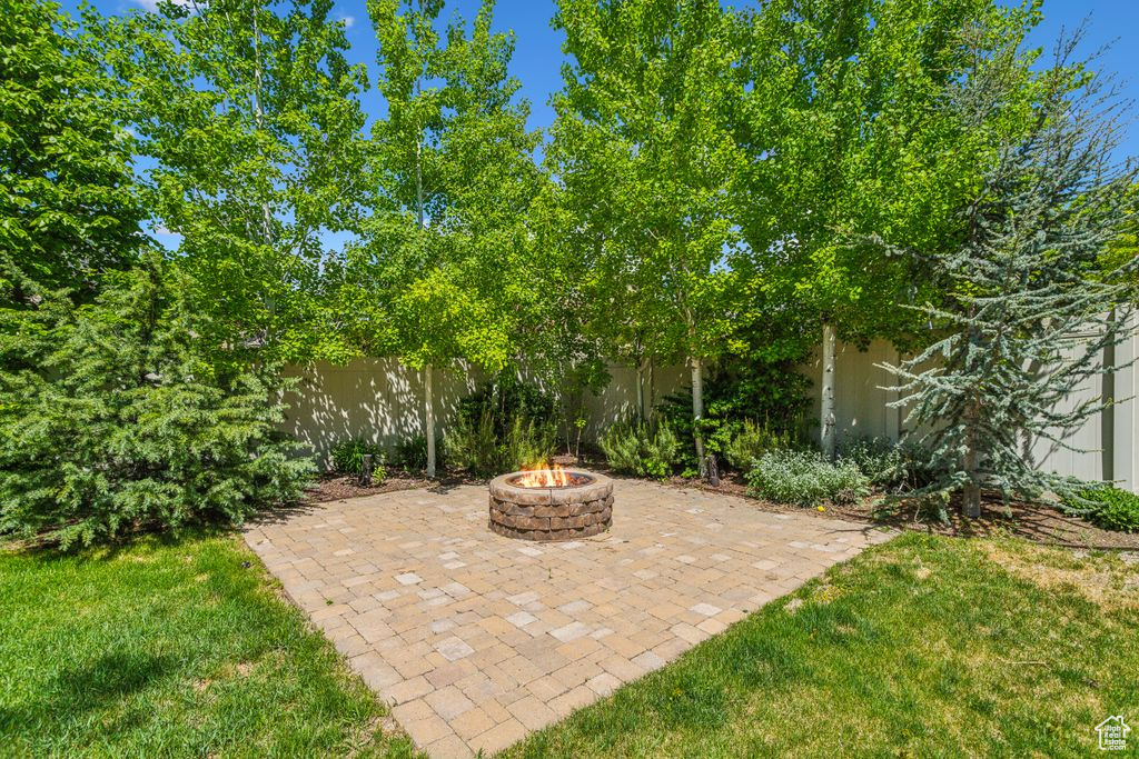 Fenced backyard with a fire pit and a patio area