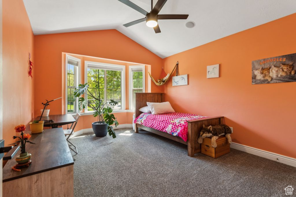 Carpeted bedroom with lofted ceiling and ceiling fan
