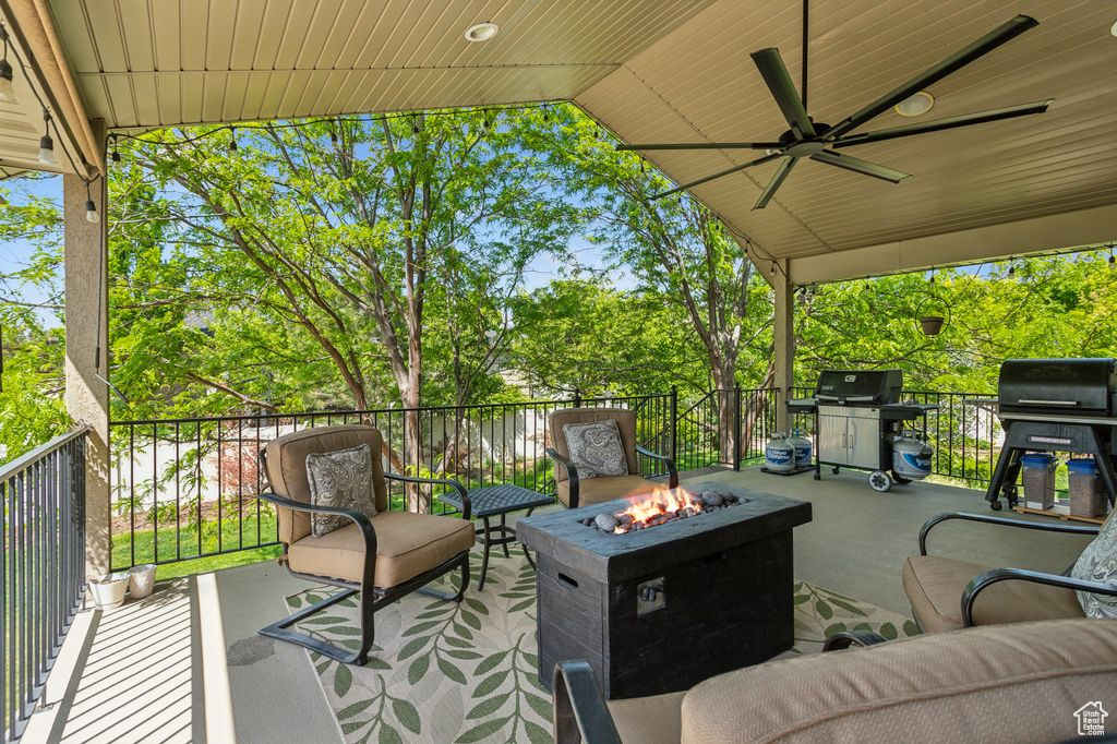 View of patio with an outdoor fire pit, area for grilling, and a ceiling fan