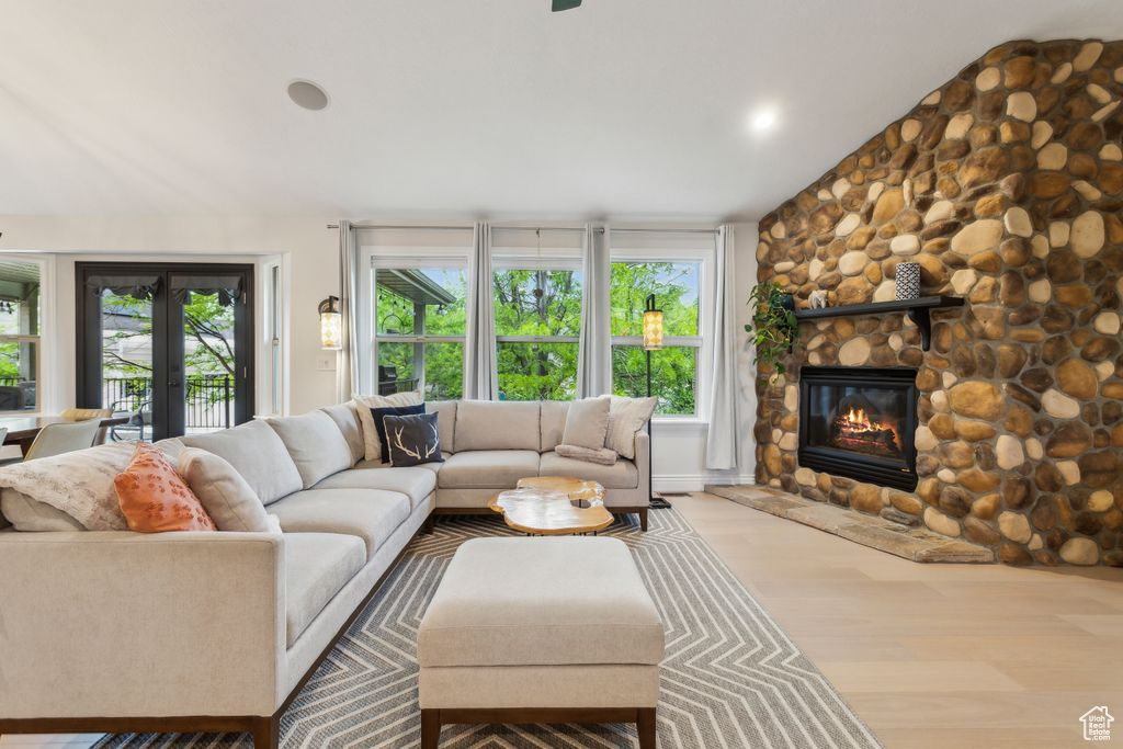 Living room featuring wood finished floors and a stone fireplace