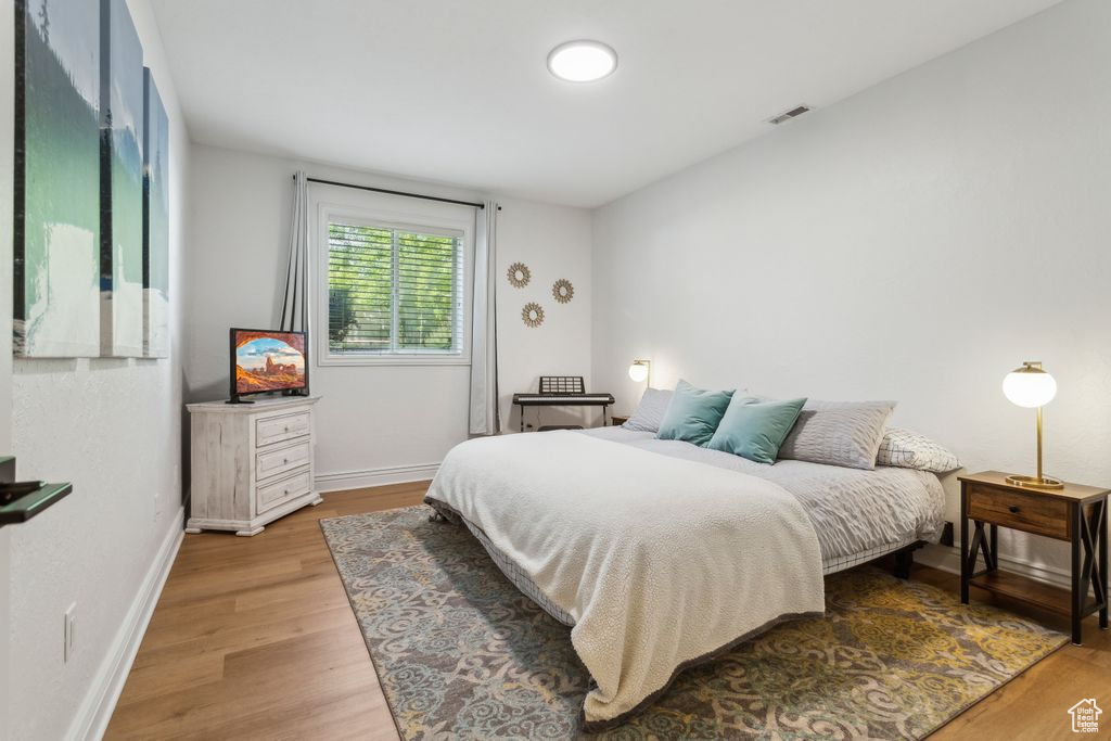 Bedroom with light wood-style flooring and baseboards