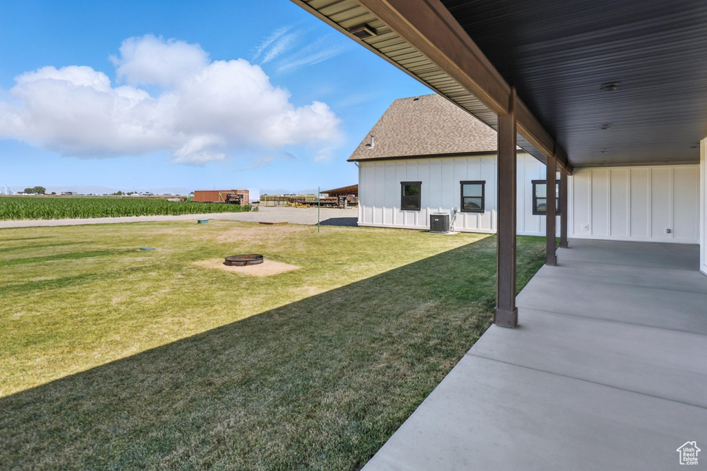 View of green lawn featuring a fire pit and a patio