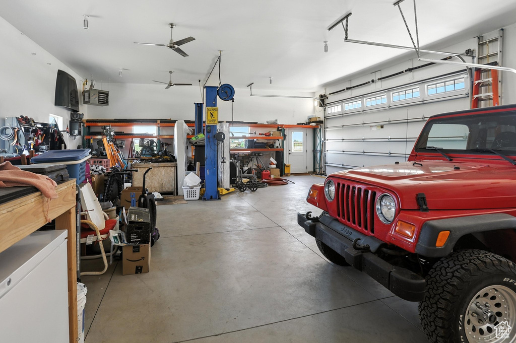 Garage featuring a ceiling fan and a workshop area