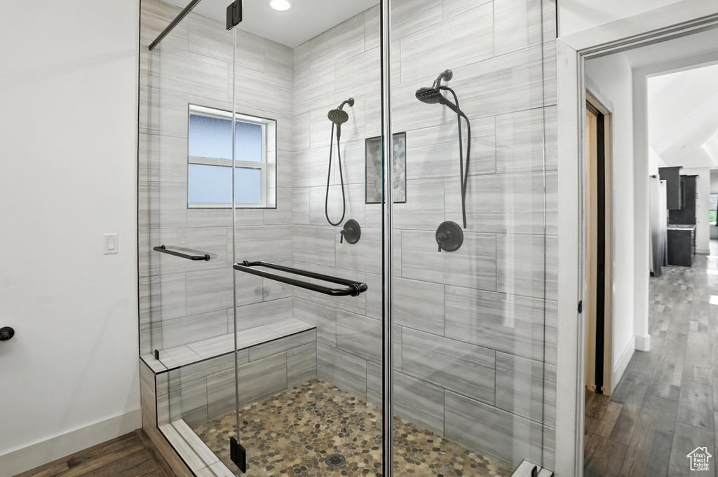 Full bath featuring a shower stall and wood finished floors