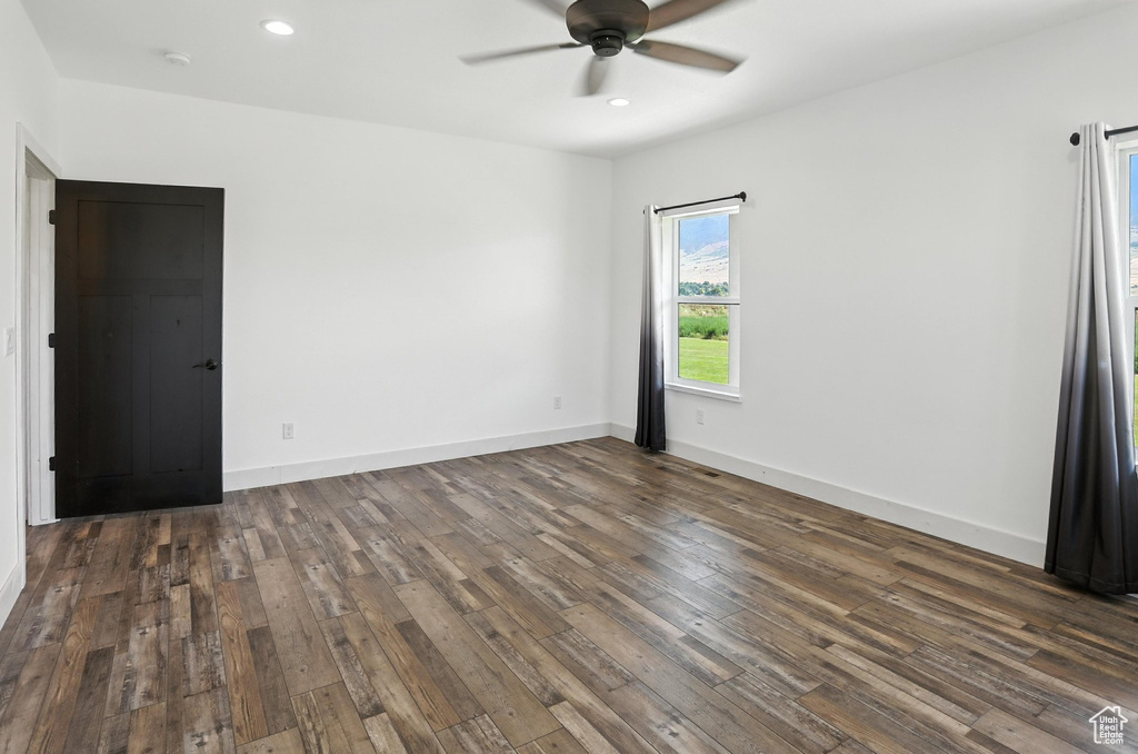 Empty room featuring a ceiling fan, dark wood-style flooring, and recessed lighting