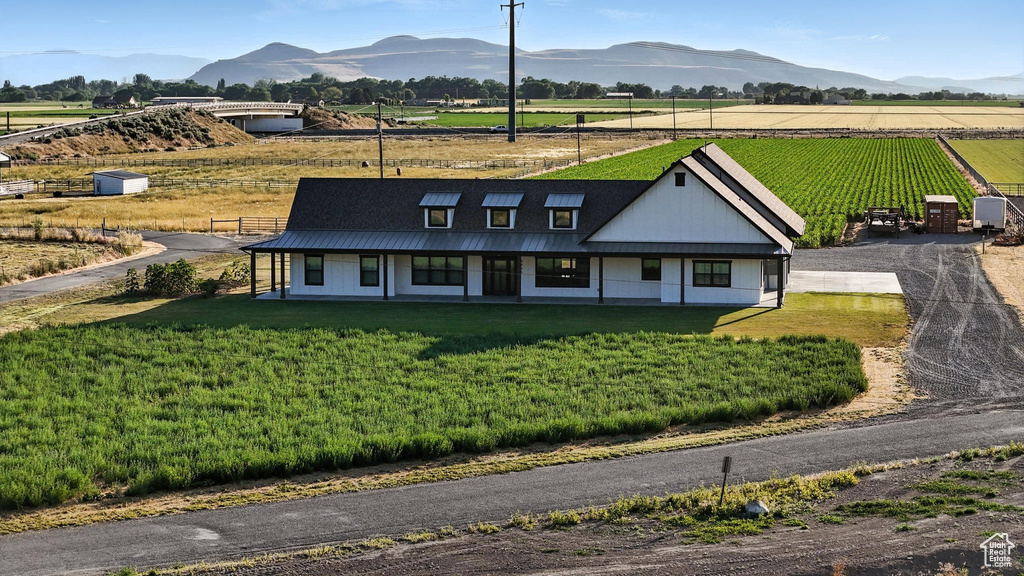 View of front of property with a mountain view, a view of rural / pastoral area, and a front yard