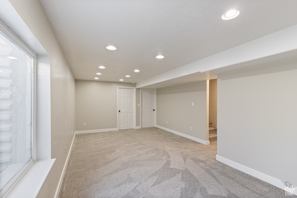Finished below grade area featuring recessed lighting and light carpet