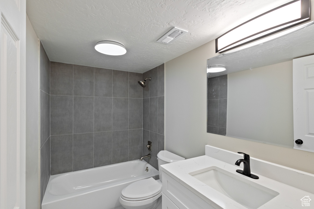 Full bathroom with vanity,  shower combination, and a textured ceiling