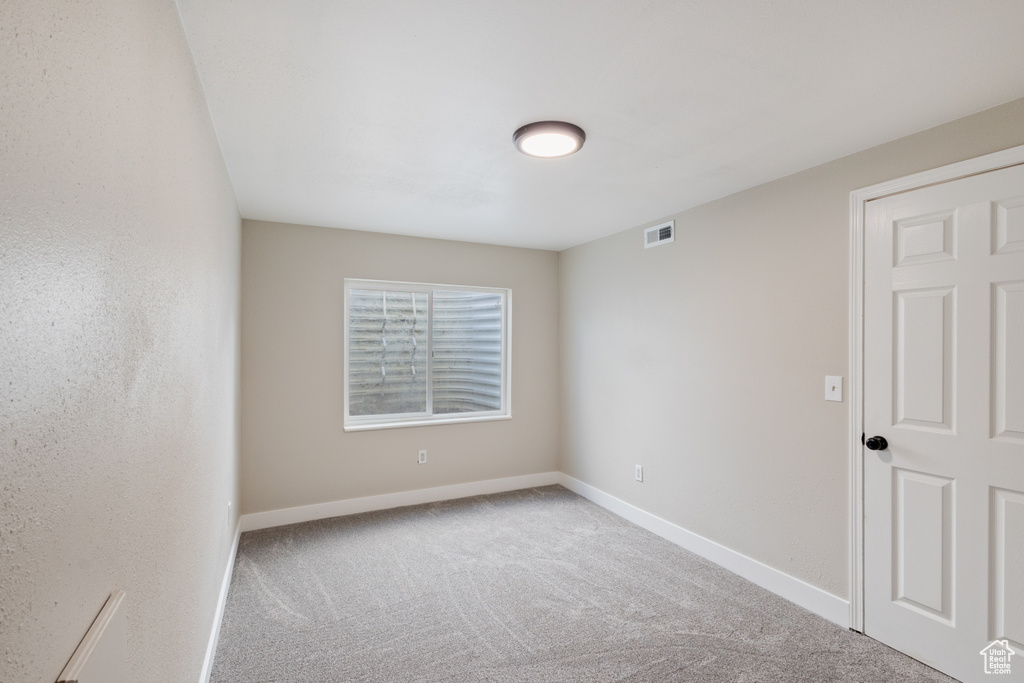 Spare room featuring carpet floors and baseboards