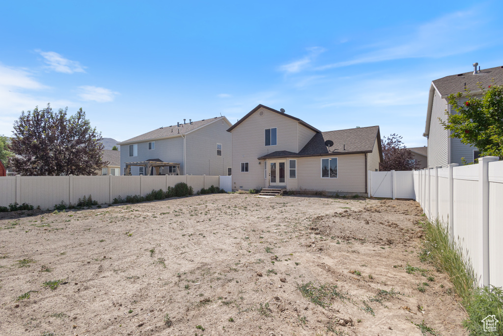 Back of property with a fenced backyard and entry steps