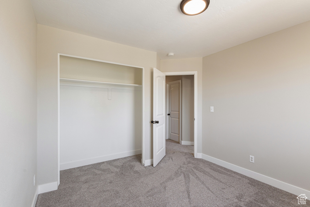 Unfurnished bedroom featuring carpet flooring and a closet