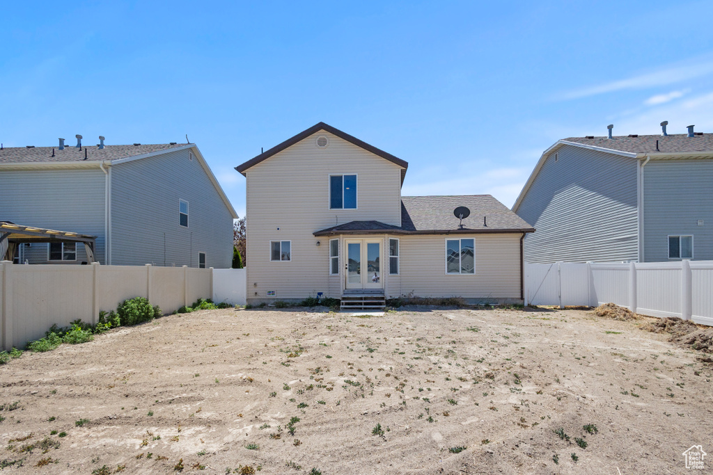 Rear view of property featuring a fenced backyard and french doors