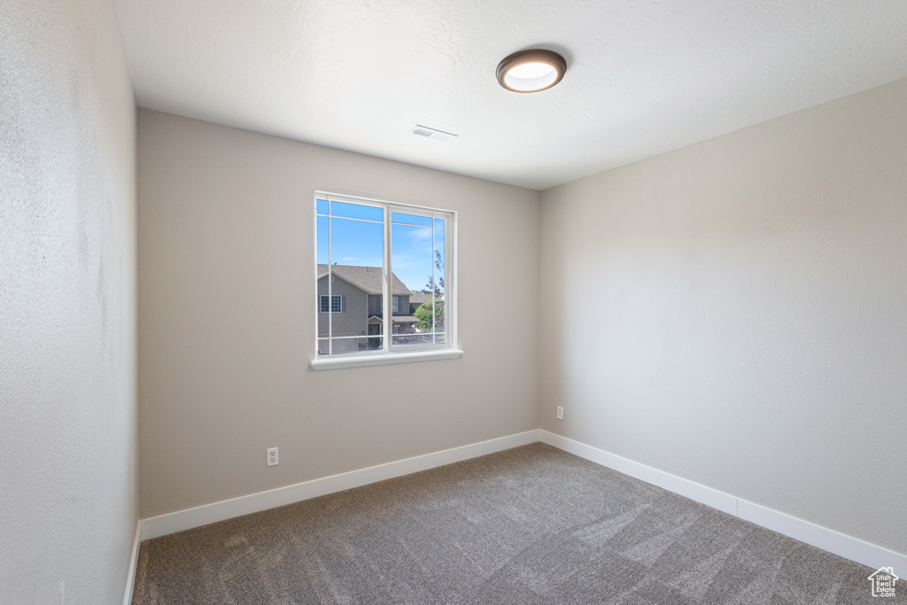Carpeted empty room with baseboards