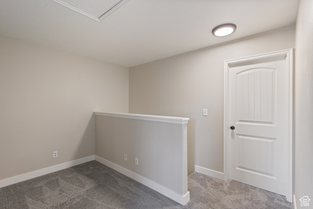 Carpeted spare room featuring baseboards