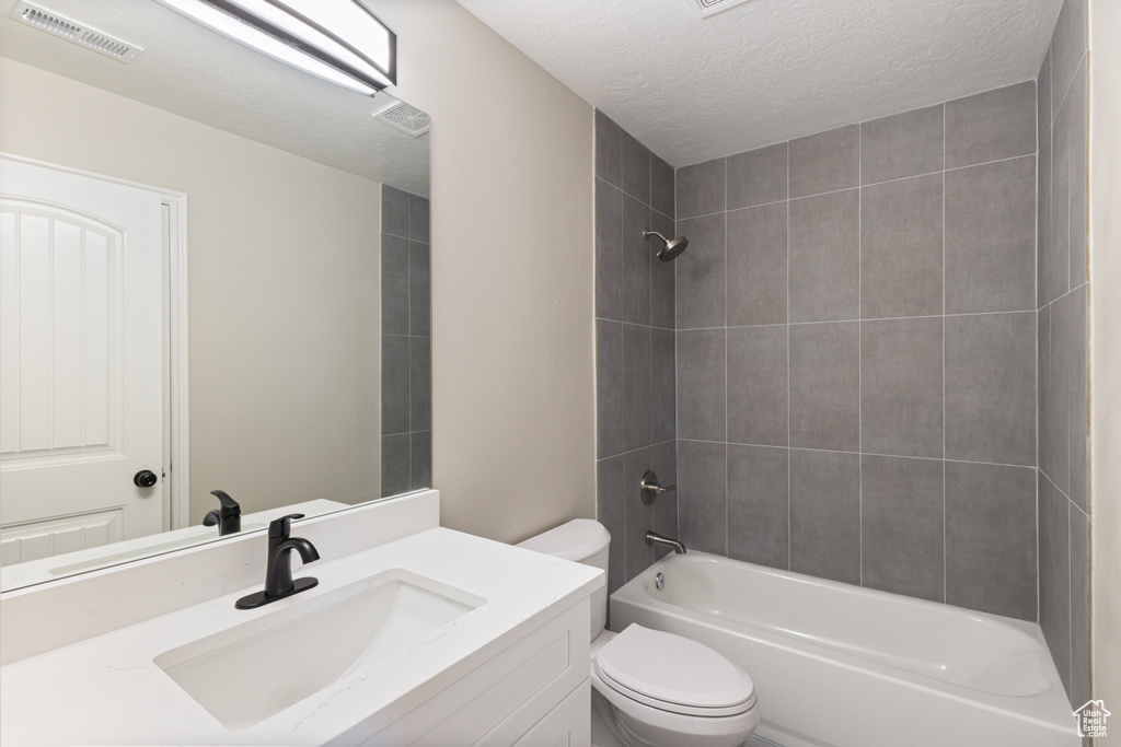 Bathroom with vanity, a textured ceiling, and bathing tub / shower combination