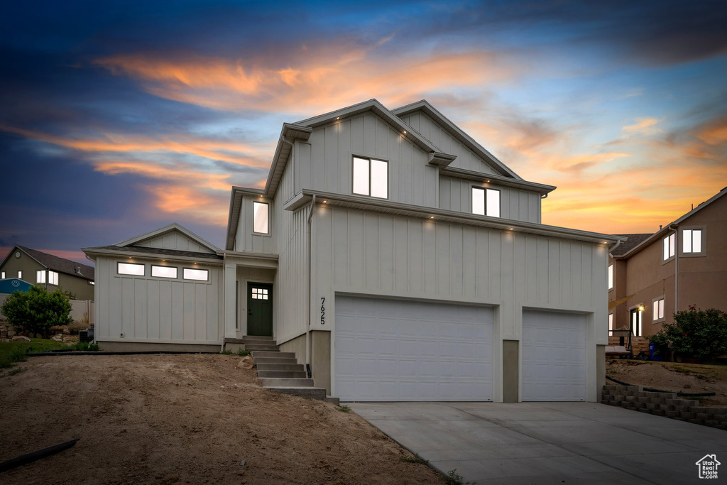 View of front of house featuring concrete driveway, a garage, and board and batten siding